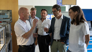 Jürgen Rigo (v.l.), Torsten Markus und Markus Grebe führen Staatssekretär Andre Baumann und Abgeordnete Susanne Aschhoff in die Tribologie ein.