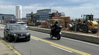 Auf dem östlichen Teil der BBC-Brücke stehen Baumaschinen und Baumaterial. Aktuell werden die Fundamente für die Behelfsbrücken vorbereitet.