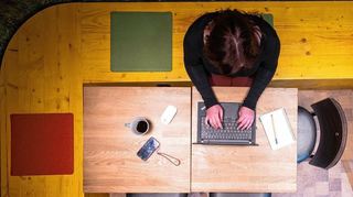 Eine Frau sitzt im Homeoffice am Küchentisch.