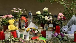 An der Unfallstelle liegen Blumen und Spielzeuge am Fuß des Hochhauses in Heidelberg-Emmertsgrund.