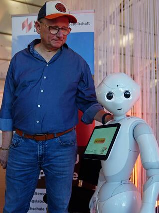 Professor Klaus Blettner von der Hochschule für Wirtschaft und Gesellschaft Ludwigshafen und sein Roboter Pepper.