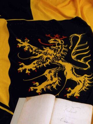 „Der König hört die Stimme des Volkes gern“, ist im Protokoll von 1816 niedergelegt – die Gründungsurkunde des heutigen Bezirkstags, dahinter die Fahne.