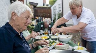 Viele Anwohner gesellen sich mit Sitzgruppen und Freunden vor dem Haus dazu und feiern mit, wie hier Doris Leone.