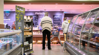 Kunden stehen an der Bedienungstheke einer Filiale von Edeka in Stuttgart an. Für die Theken fehlt den Handelsketten Personal.
