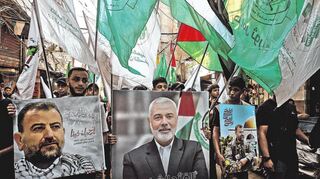 Palästinensische Flüchtlinge schwenken Fahnen und tragen Bilder des Führers der Hamas-Gruppe, Haniya (Mitte), und des hochrangigen Führers al-Arouri im Flüchtlingslager Burj al-Brajneh, um gegen die Ermordung Haniyas zu protestieren.