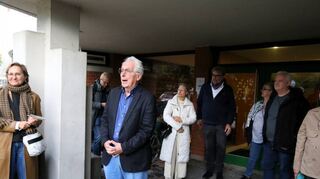 Einald Sandreuther erklärt das evangelische Gemeindezentrum. Die Menschen lauschen ihm.