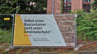 Ob selbst Baucontainer unter Denkmalschutz stehen, mag dahin gestellt sein – aber die alten roten Sandsteingebäude schon.