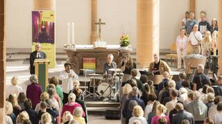 Voll besetzte Reihen beim Adele-Gottesdienst in Heidelberg: Pfarrer Vincenzo Petracca (l.) hatte neben der Band auch einen Tänzer eingeladen.