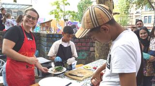 Am Stand der Jungen Diakonie wird Filiz Kuyucu (l.) bei der Pide-Ausgabe unterstützt von Shanel von der Kinderkochgruppe Genussconnection, rechts sein Bruder Veslim.