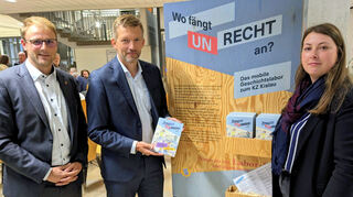 Ladenburg, 24.09.2024. Die beiden Bürgermeister Florian König und Stefan Schmutz stehen mit Fabienne Bitz vom mobilen Geschichtslabor zum KZ Kislau an der ersten Station der Ausstellung.