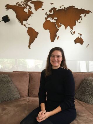Hannah Mieger-Höfer vor der Weltkarte in ihrem Wohnzimmer.