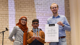 Afia Mansoor Ahmed und ihr Neffe Kashif nehmen den Demokratiepreis entgegen. Rechts: Laudator Thilo Dieing.