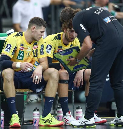 Die Mittelblockspieler Sebastian Heymann (v.l.) und Olle Forsell Schefvert im Gespräch mit Trainer Sebastian Hinze.