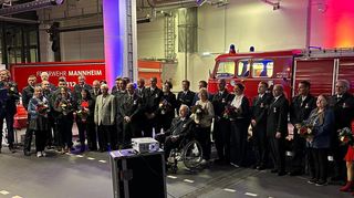 Bewusst mit Ehepartnern geehrt: die Jubilare der Feuerwehr bei der Auszeichnung, rechts ein historisches Tanklöschfahrzeug von 1959.