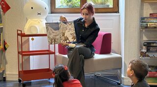 Die Lehramtsstudentin Valeria Scafaru liest den Kindern zum Projektstart das Buch Yeti Jo auf Deutsch und auf Russisch in der Stadtbibliothek Ladenburg vor. Die Kinder hören gespannt zu.