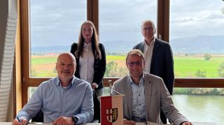 Ralf Schrauder (E1, l.) und Bürgermeister Florian König besiegeln das Contracting, Mariia Vershkova und Klaus Keßler blicken ihnen über die Schulter.