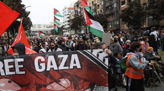 Teilnehmer einer propalästinensischen Demonstration in Berlin halten ein Transparent mit der Aufschrift „Free Gaza“ hoch.