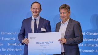 Minister Robert Habeck (r.) übergibt einen Klimaschutzvertrag an Uwe Liebelt, Betriebsleiter bei der BASF SE.