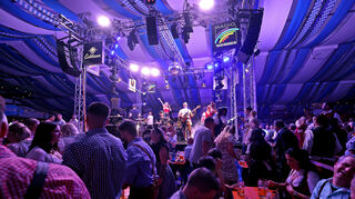 Die Band "Störzelbacher und Strings" heizt den Besucherinnen und Besuchern ein. Die meisten sind in Tracht gekommen.