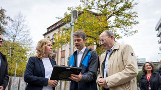 Robert Thomann, Chef der Mannheimer Smart City-Gesellschaft (M.), und Oberbürgermeister Christian Specht erklären Bundesumweltministerin Steffi Lemke das Klimamessnetz.