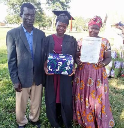 Eine Absolventin der Nähschule in Uganda mit ihren Eltern.