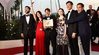Sean Baker, Regisseur und Drehbuchautor aus den USA, (3.v.l.), posiert nach der Preisverleihung in Cannes inmitten seines „Anora“-Casts.