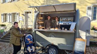 Kundin Anja Hoecker kauft Sohn Oscar bei Laura Goduti-Meurer (l.) und Carolin Rinck am Verkaufsanhänger der Pâtisserie Pastry Poets ein Croissant.