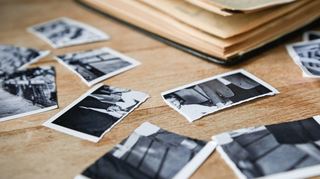 Zerrissene Kinderbilder liegen neben einem aufgeschlagenen Fotoalbum. Viele Missbrauchsopfer tragen die Folgen ein Leben lang.
