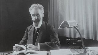 Hugo Stotz an seinem Schreibtisch, vermutlich in den 1920er-Jahren. Rechts ein Sicherungsautomat, wie man ihn heute kennt.