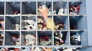Mitarbeiter einer Recyclingfirma sortieren Klamotten aus der Altkleidersammlung. Die EU will erreichen, dass mehr Textilien wiederverwendet werden.