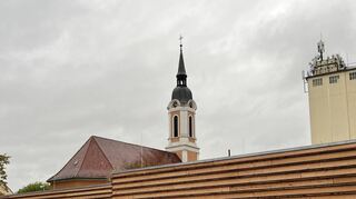 Für das neue Gemeindehaus in Edingen (vorn) steht die Ampel auf Grün, für die Kirche (hinten) auf Rot.