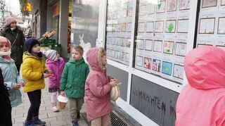 Wo ist nur das eigene Weihnachtsbild? Kinder zwischen drei und elf Jahren holen sich für ihr Kunstwerk im Schaufenster ein Präsent im Laden ab.