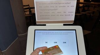 Das weiße Spenden-Tablet ist von einem Software-Dienstleister aus Deutschland und steht vorerst am Seiteneingang in der Kirche.