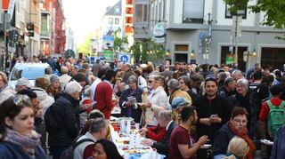 Eine lange Tafel aus Tischen, festlich gedeckt und mit Spezialitäten aus aller Welt: Das ist die „Meile der Religionen“, hier 2016.