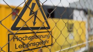 Ein Schild warnt an der Baustelle des Umspannwerks in Weinheim vor Hochspannung.