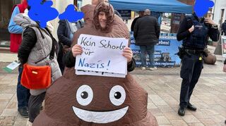 Patrick Christmann hat sich ein „Kackhaufen“-Kostüm in China bestellt und damit die AfD am Wahlkampfstand in Neustadt konfrontiert.
