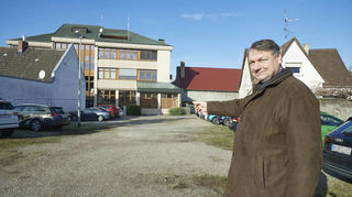 Bürgermeister Volker Scheib zeigt auf das Gelände hinter dem Rathaus, das zu einem Multifunktionsplatz umgebaut werden soll. Auf dem könnte dann auch ein Markt stattfinden.