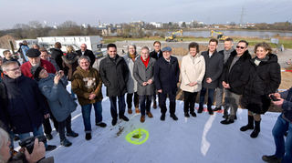 Festlicher Baubeginn an der Neckarbrücke bei Ladenburg mit Minister Winfried Hermann (Mitte mit Mütze) und Regierungspräsidentin Sylvia Felder (rechts daneben).