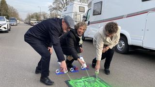 Erste Bürgermeisterin Diana Pretzell (M.), Landesverkehrsminister Winfried Hermann (l.) und Regierungspräsidentin Sylvia M. Felder versehen die Spessartstraße symbolisch mit dem Zeichen einer Fahrradstraße.