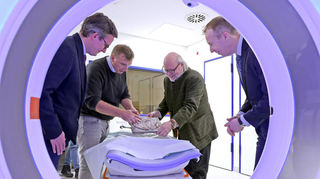 Versteinerte Saurier in der Radiologie: v. l. Matthias Frölich, Sebastian Voigt, Wilfried Rosendahl und Stefan Schönberg am Photon-Counting-Computertomographie-Gerät.