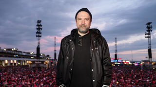 Portrait von DreamHaus-Chef Matt Schwarz auf der Utopia Stage, kurz vor dem Auftritt von Green Day, beim Festival Rock am Ring am Nürburgring in der Eifel am 8. Juni 2024. Im Hintergrund das mit Besuchern gefüllte Festivalgelände.