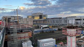 Teile der Behelfsbrücken für den motorisierten Verkehr (l.) und für Radfahrer sowie Fußgänger auf der Baustelle der BBC-Brücke in Mannheim umgeben die Oberleitungsmasten der Deutschen Bahn.