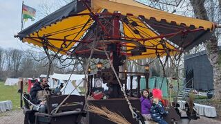 Kinder freuen sich über ein historisches Karussell auf dem Mittelalterlichen Jahrmarkt.