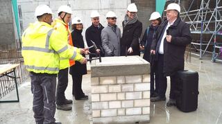 Mit drei Hammerschlägen nach alter Tradition wird die Betonplatte verschlossen. Von links: die Poliere Tahirivic Adem und Tobias Fritz, Eugenie Bauer (Projektleiterin Vermögen und Bau), Rektor Thomas Fetzer, Bürgermeister Ralf Eisenhauer, Architekt Baldur Dilthey, Uni-Kanzlerin Kathrin Schoppa-Bauer und Marco Grübbel.