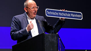 Oberbürgermeister Christian Specht hat der Technischen Hochschule Mannheim zur Umbenennung ein Schild mitgebracht.