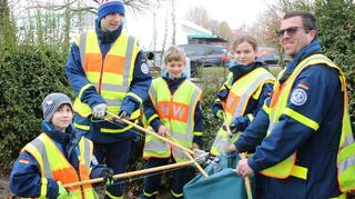 Mitglieder der THW-Jugend finden zahlreiche Fläschchen im Gebüsch.