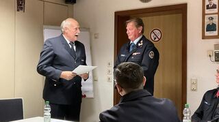 Ex-Kreisbrandinspektor Wolfgang Müller (links) übereicht Rupert Getrost die Goldene Ehrennadel und übergibt ihn an die Ehren- und Altersabteilung