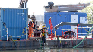 Taucher steigen von Bord der Perun in den Neckar, um nach möglichen Kampfstoffrelikten zu suchen. Eine Vorsichtsmaßnahme vor dem Bau der neuen Neckarbrücke zwischen Ladenburg und Neckarhausen.