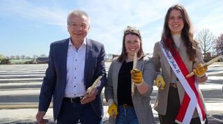 Bürgermeister Gottfried Störmer, Gebietsweinkönigin Katja I. (Mitte) und Spargelkönigin Julia II. zeigen stolz ihren gestochenen Spargel.