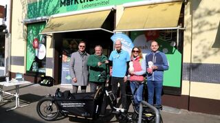 Bürgermeister Ralf Eisenhauer (v.l.), Marktleiter Roger Zimmermann, LaMa Vorstand Matthias Philippp, Henrike Zeilfelder (GBG) und SPD-Bezirksbeirat Marco Rohr bei der Schlüsselübergabe eines Lastenfahrrades, das ab sofort ausgeliehen werden kann.
